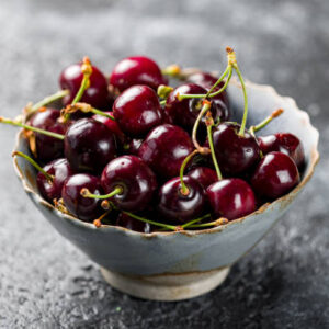 Cherries in a plate on a dark concrete background close up