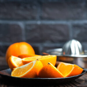 Fresh oranges on the wooden board and on a table