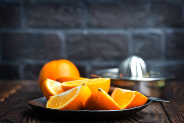 Fresh oranges on the wooden board and on a table