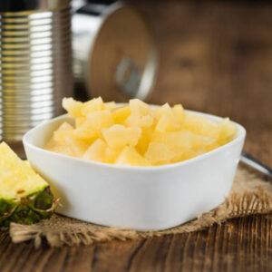 Portion of fresh preserved pineapple pieces close up shot; selective focus