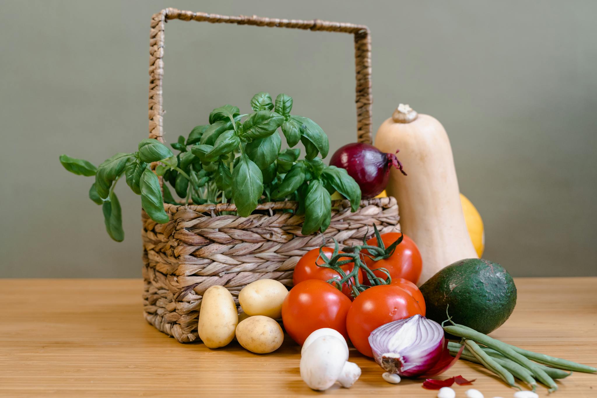 Organic vegetables and herbs displayed in a wicker basket, highlighting a healthy lifestyle.